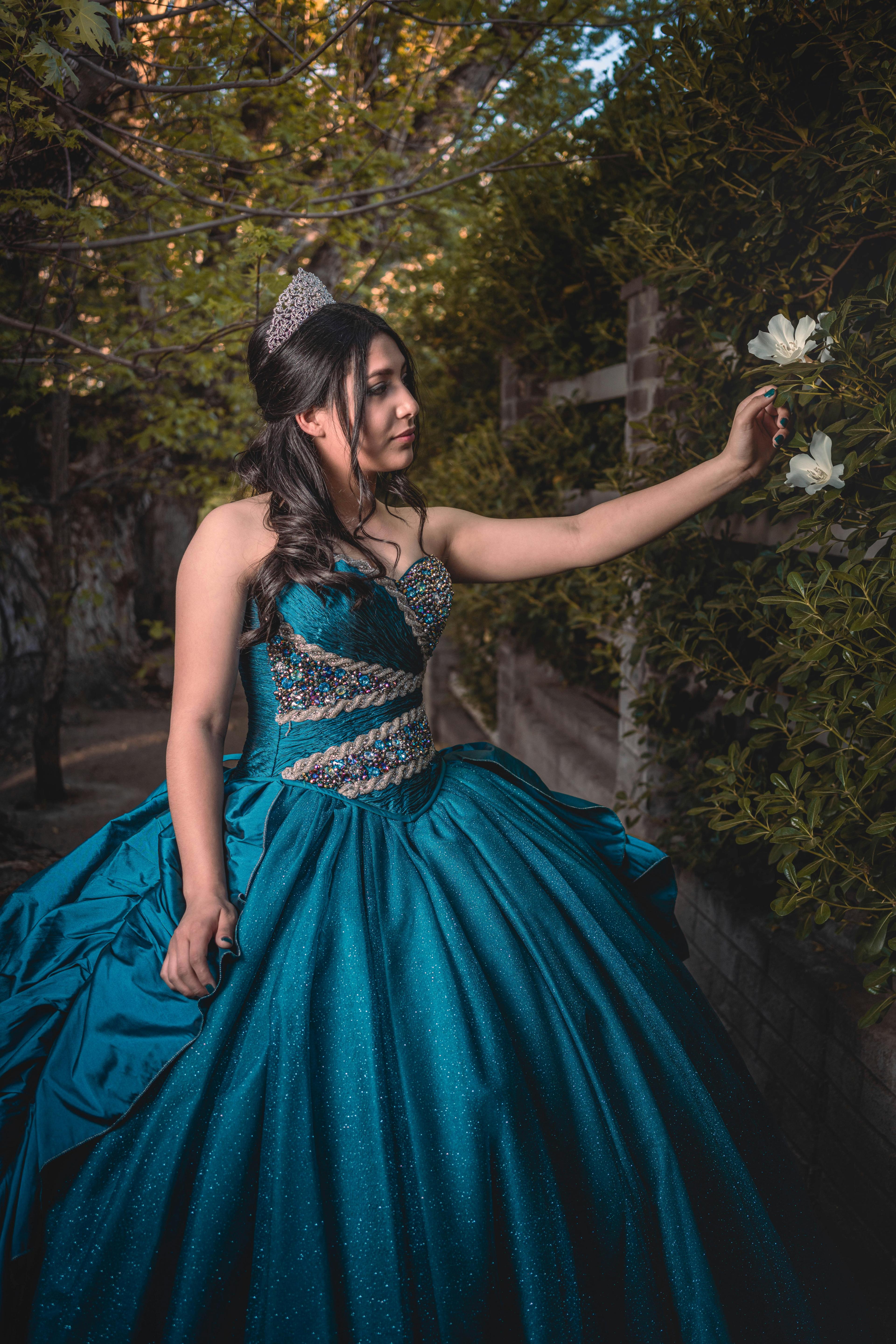 Debutante de vestido azul segurando flor