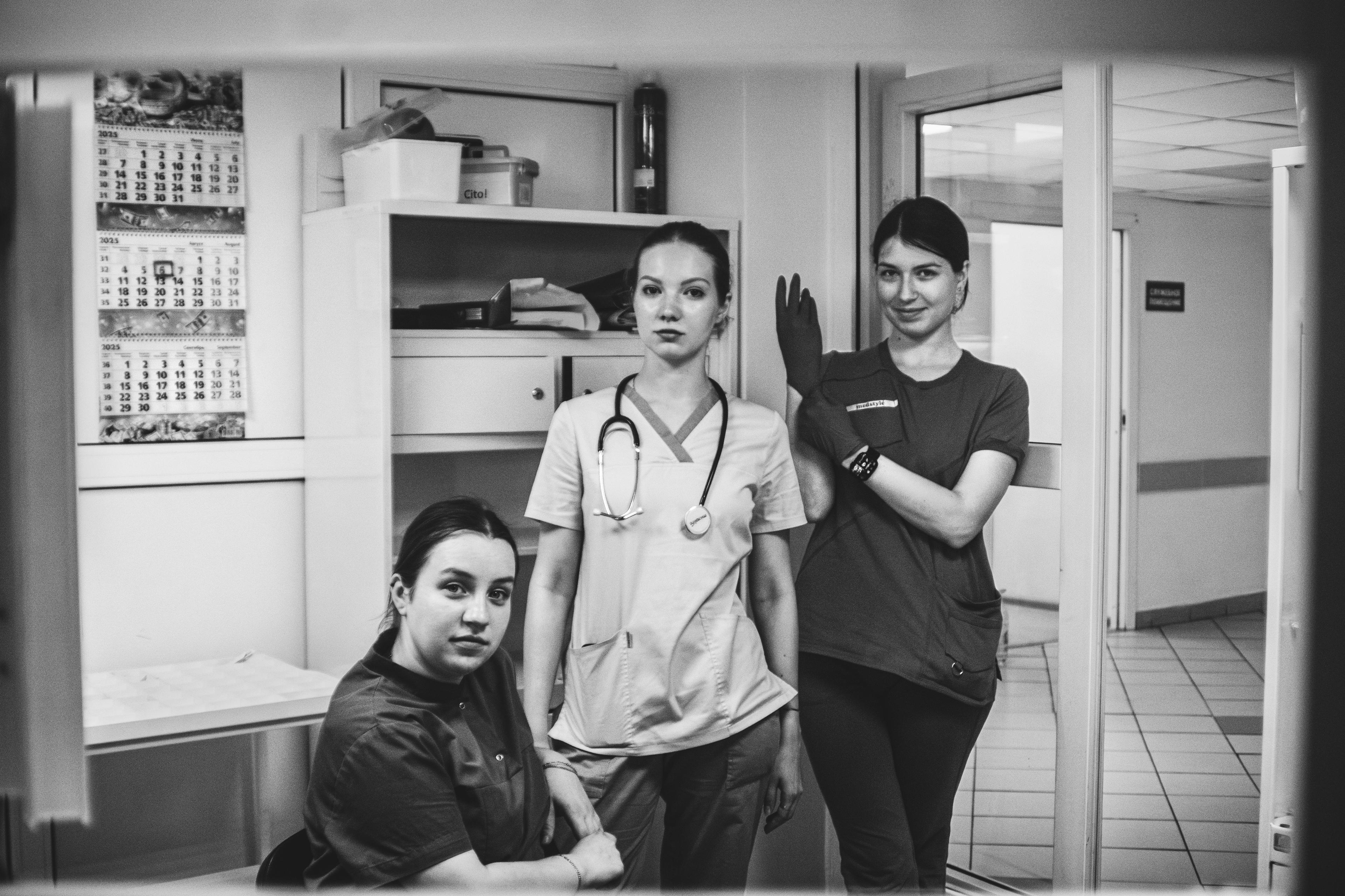 Três médicos posando no corredor do hospital