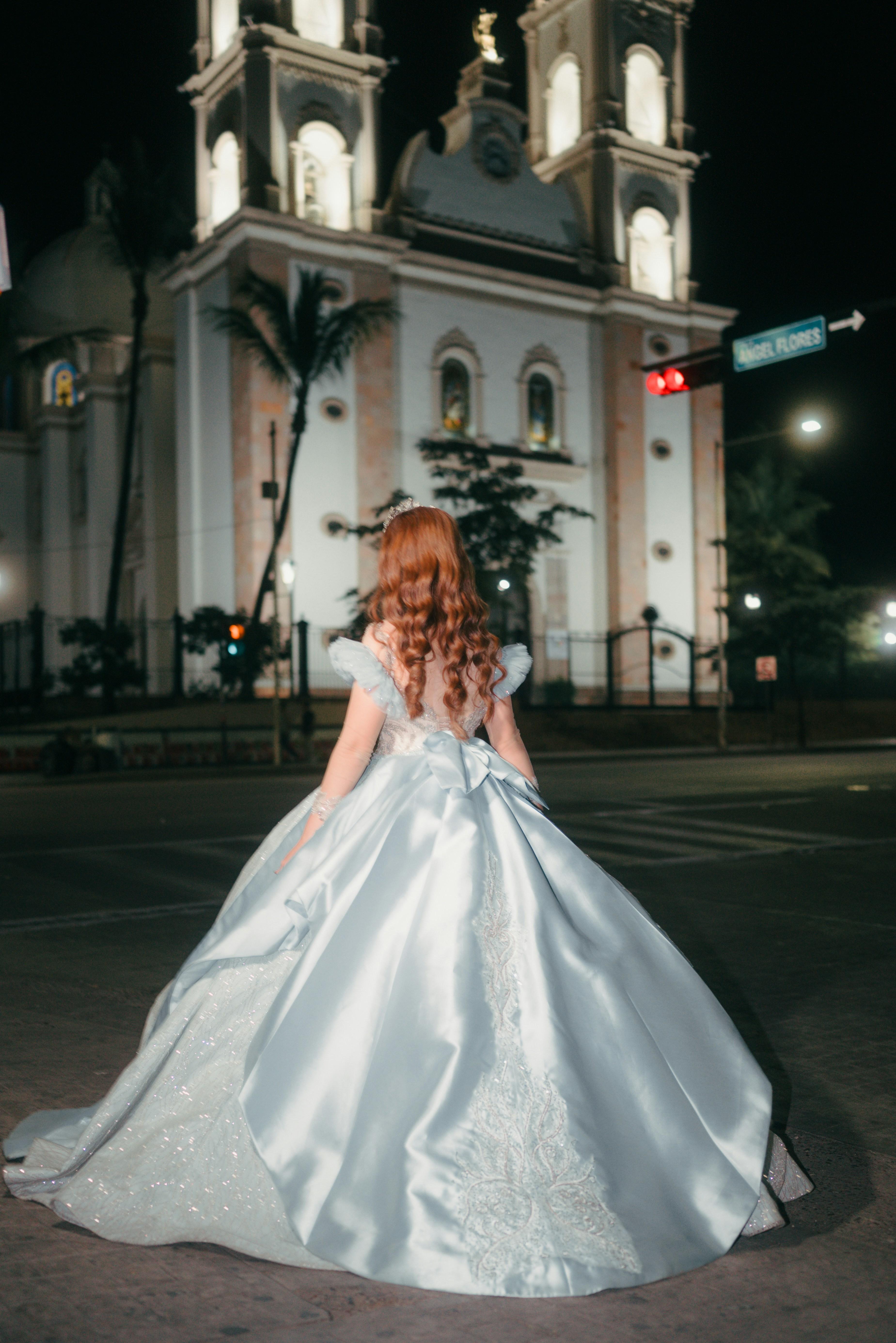 Debutante de vestido em frente à igreja iluminada
