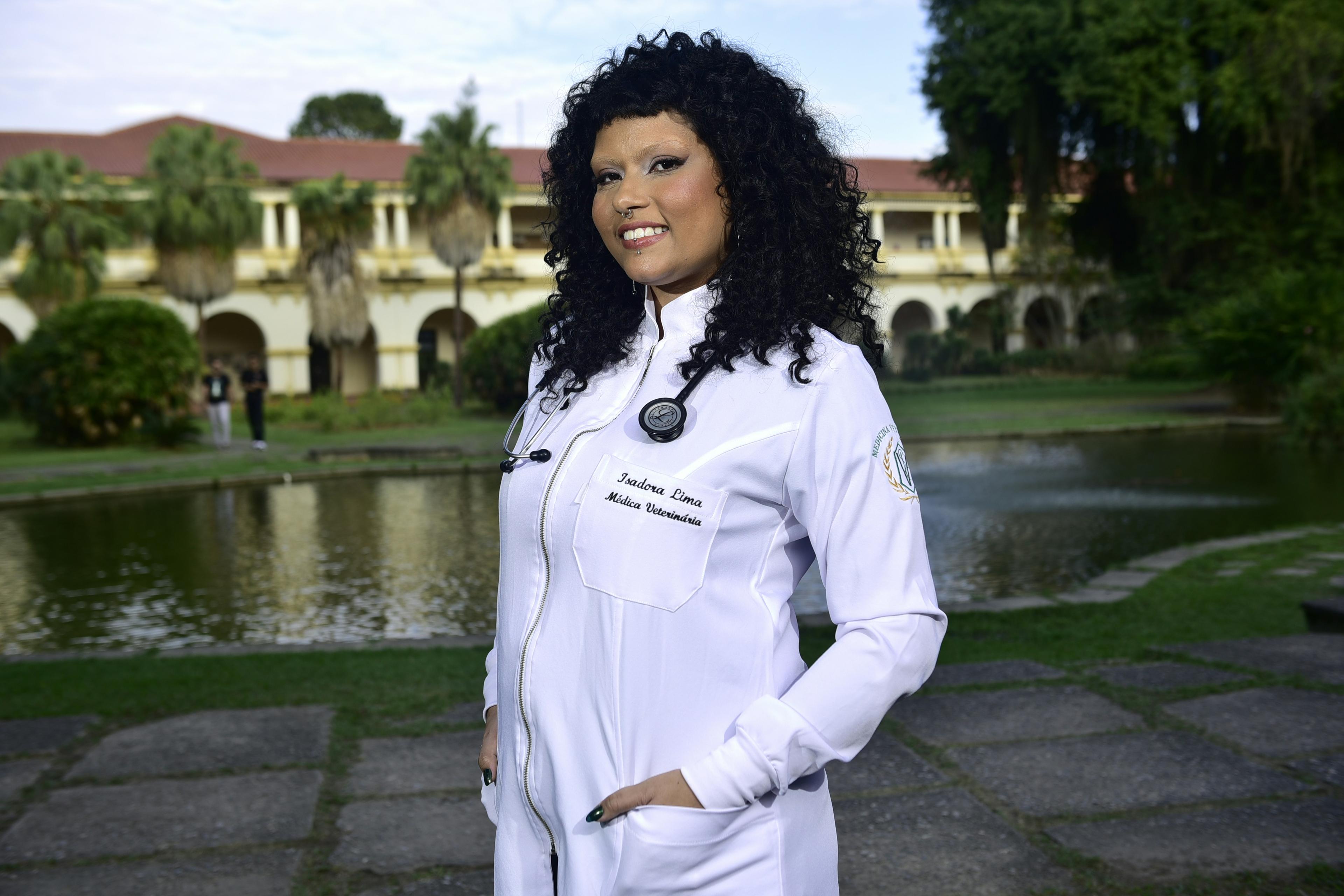Médica sorrindo de jaleco e estetoscópio