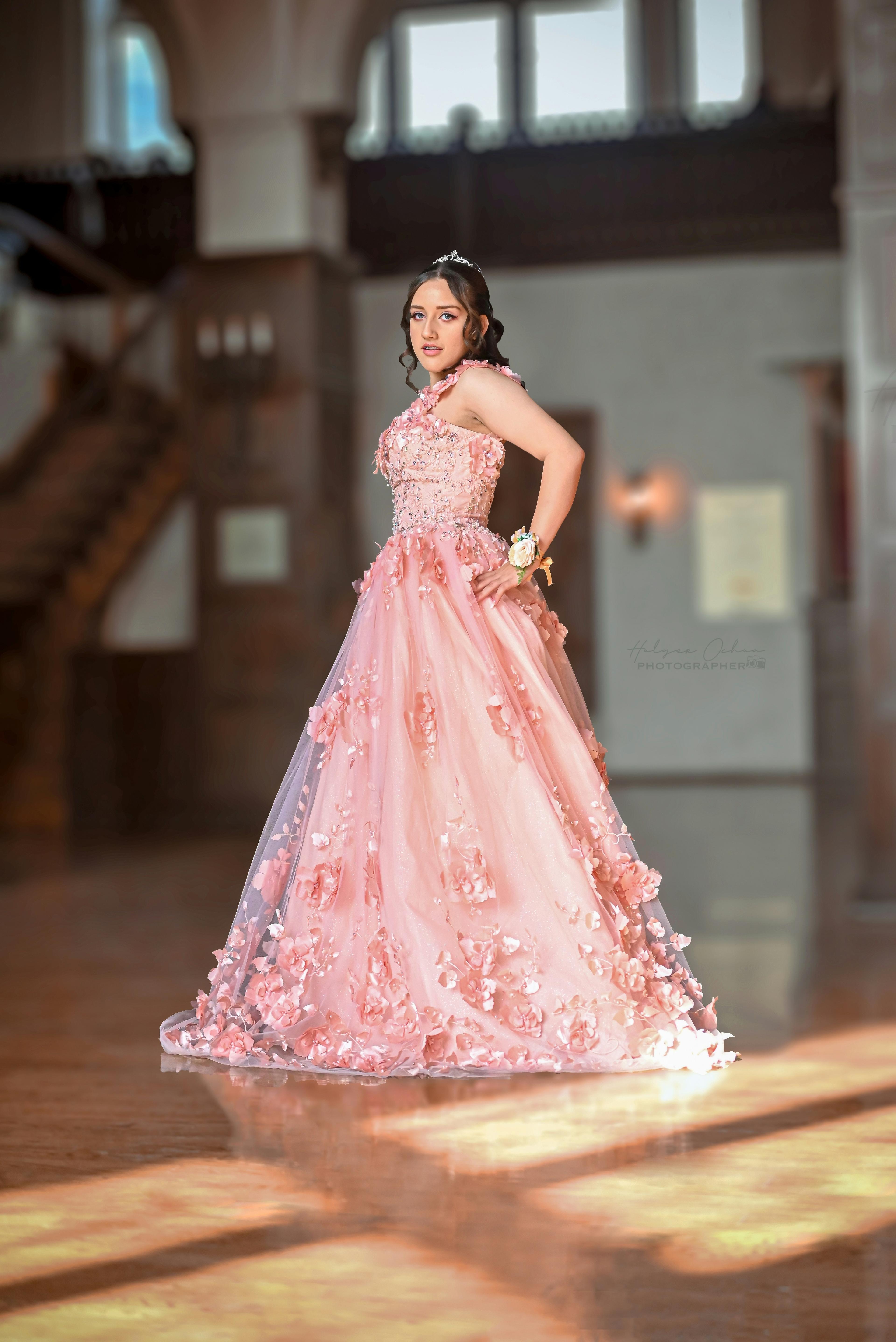 Debutante de vestido rosa e tiara no salão